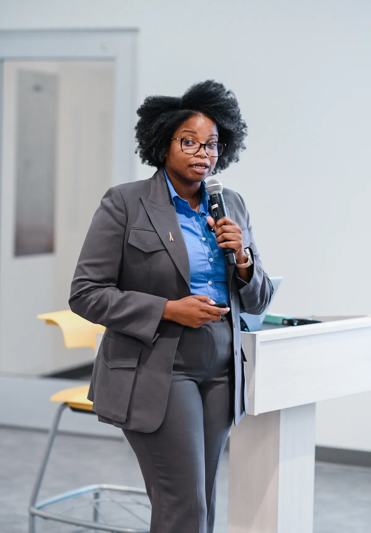 Dr. Maya Byfield speaking with a microphone beside a lectern