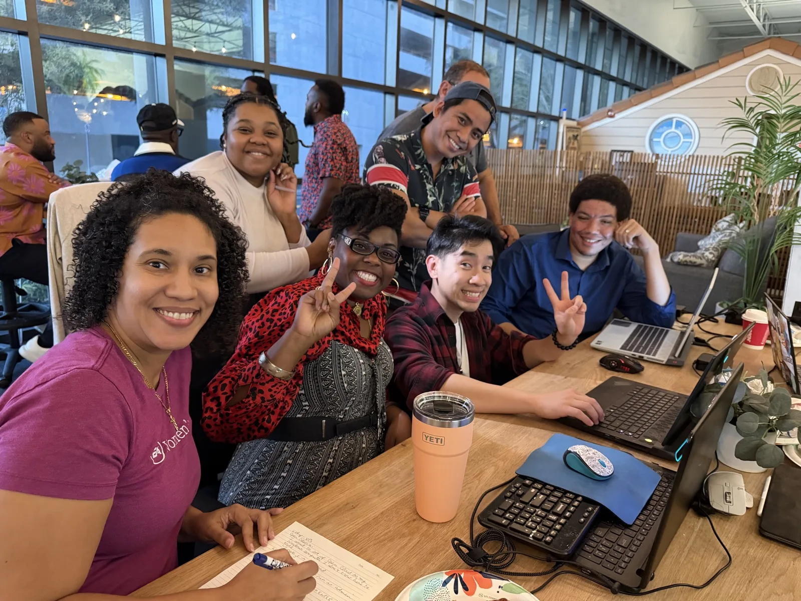 Cohort members working together around a table of laptops