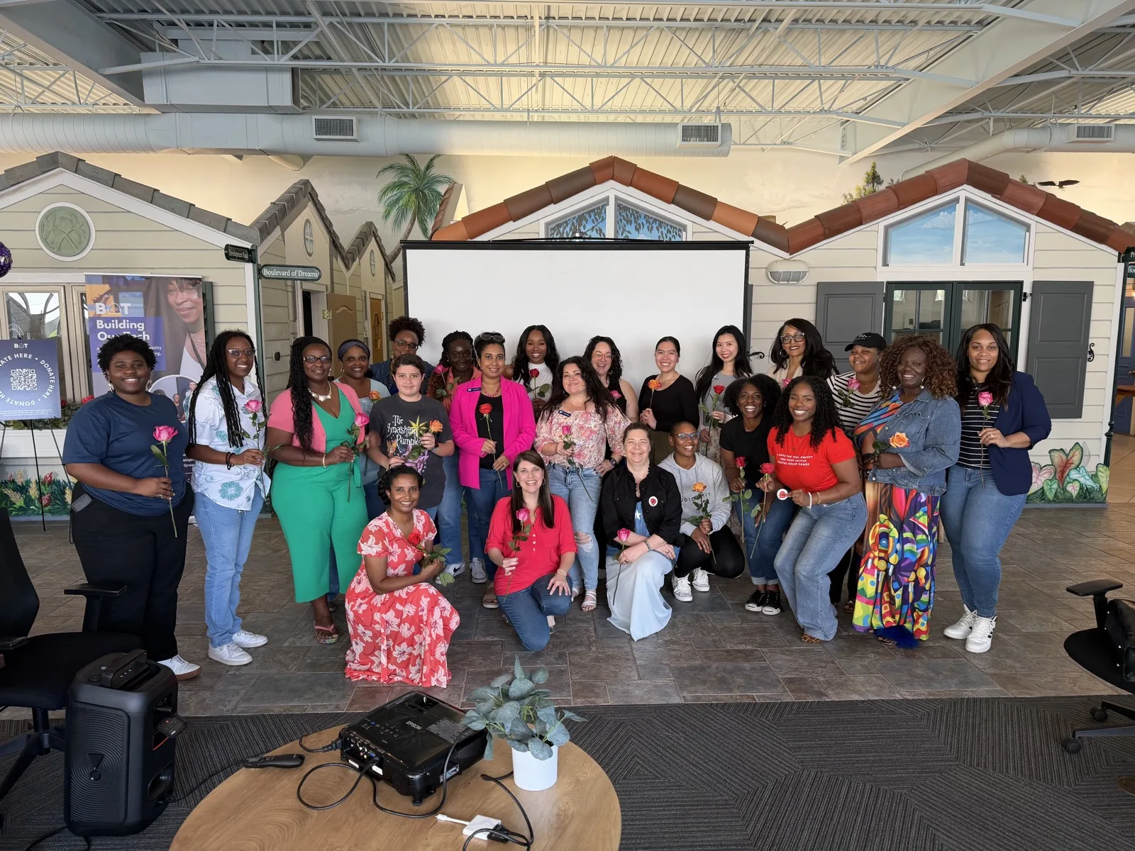 Around twenty-five women holding roses at a Women Who Build event hosted by Building Our Tech in Orlando