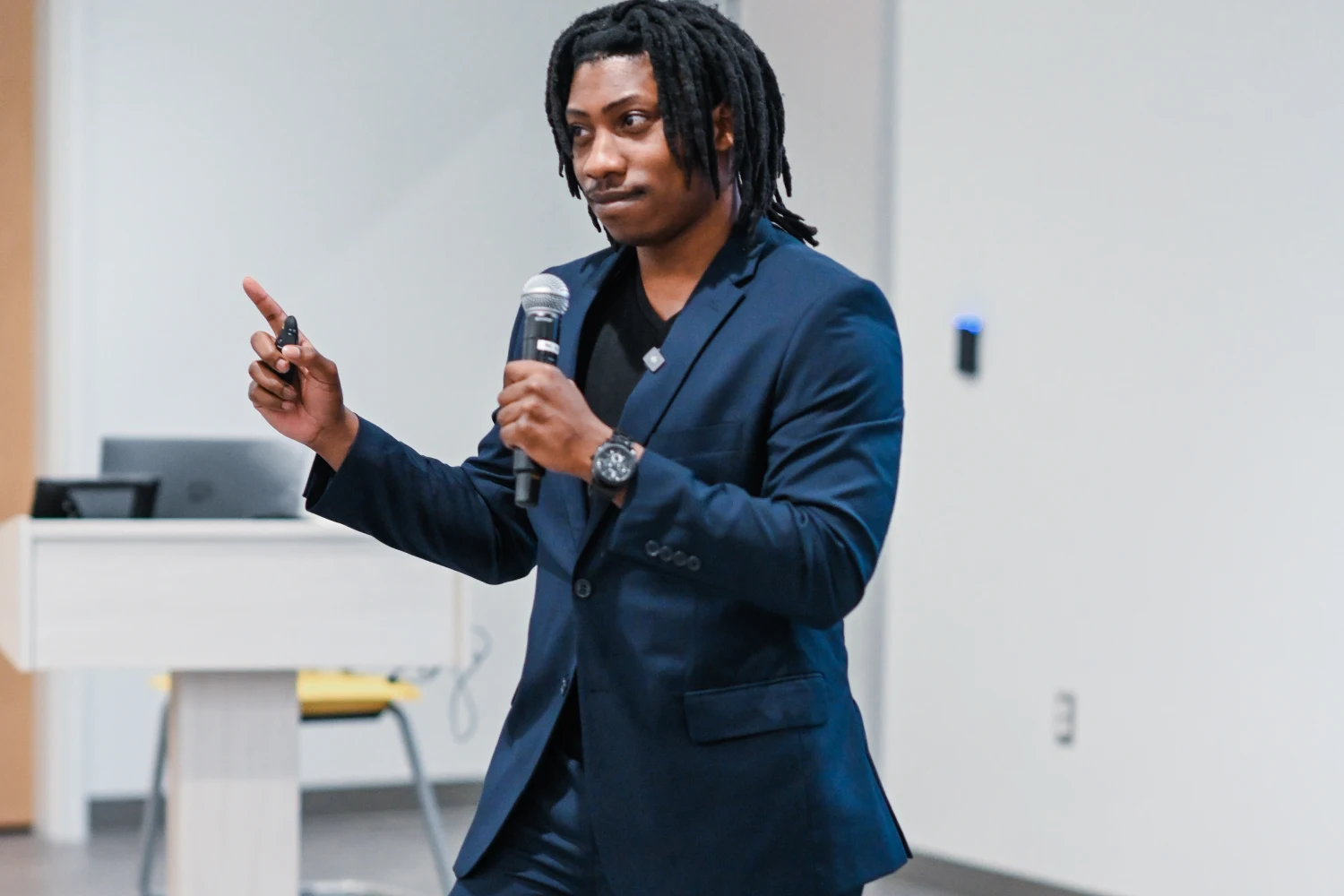 A founder mid-pitch with a microphone at a Building Our Tech pitch competition