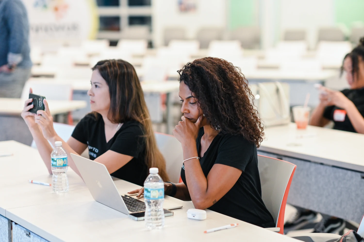 Two founders working at their laptops at a Building Our Tech event